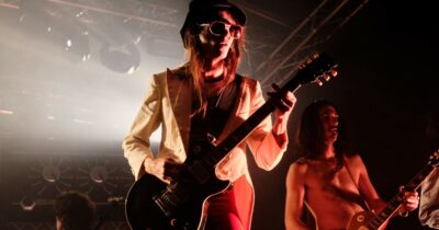 Copertina di Un Elfo maremmano e la potenza del glam rock: la magia di Lucio Corsi a Capannelle tra Bowie, favole e perline spaziali