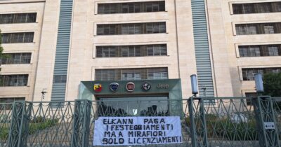 Copertina di Stellantis, striscione contro Elkann fuori dalla sede di Torino: “A Mirafiori solo licenziamenti” – Video