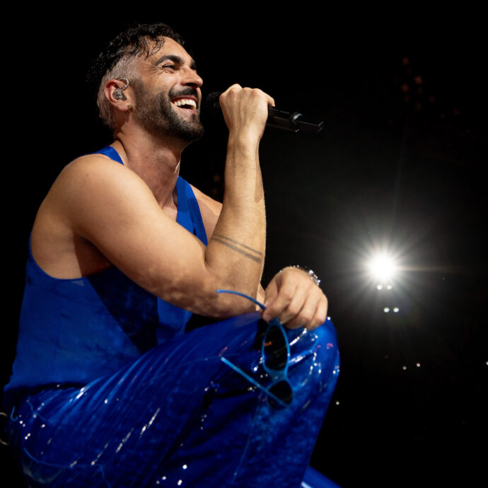 Marco Mengoni in concerto attraversa il dolore del buio e del lutto, si tuffa nella rinascita e oltrepassa i confini per sentirsi vivo (sì, c’entrano anche i corsetti): “Se non sono me stesso ora, forse non lo sarò mai più”