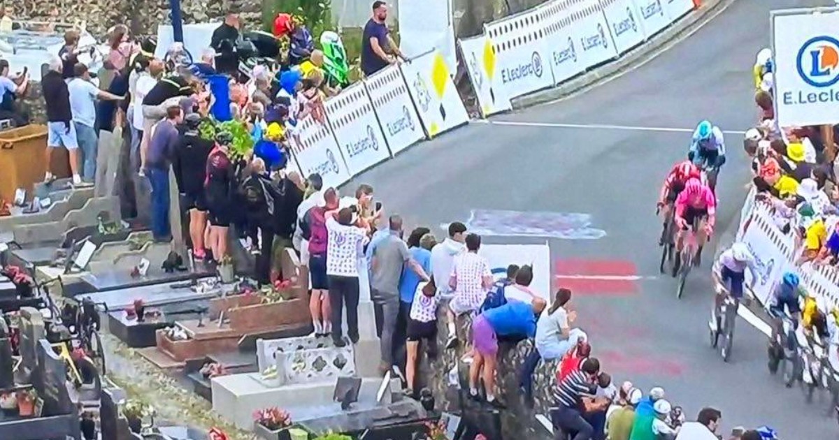 Tifosi irrompono in un cimitero e salgono in piedi sulle tombe per vedere i ciclisti: sdegno al Tour de France Tifosi irrompono in un cimitero e salgono in piedi sulle tombe per vedere i ciclisti: sdegno al Tour de France