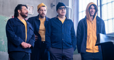 Copertina di “I tormentoni mi hanno sempre rotto i cog**oni. Bene non ci sia quest’anno. La cosa più rock della mia vita? Rompere una vetrata con una pentola”: parla Elio