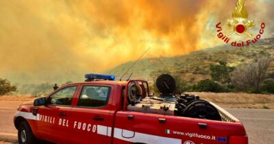 Copertina di Villasimius, fiamme sulla spiaggia: bagnanti in fuga, soccorsi dal mare. Cosa resta dopo il rogo | Video