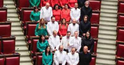Copertina di Deputati M5s si vestono da bandiera della Palestina in Aula: “Vi siete voltati dall’altra parte, siamo oltre il genocidio”