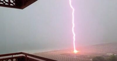 Copertina di Il fulmine cade in spiaggia tra gli ombrelloni a Lignano Sabbiadoro: le immagini
