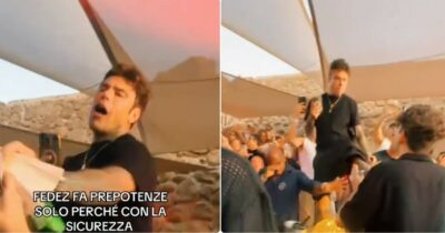 Copertina di “Fa il prepotente solo perché è con la sicurezza”: Fedez infastidito tira un calcio verso il fan che lo riprende – VIDEO