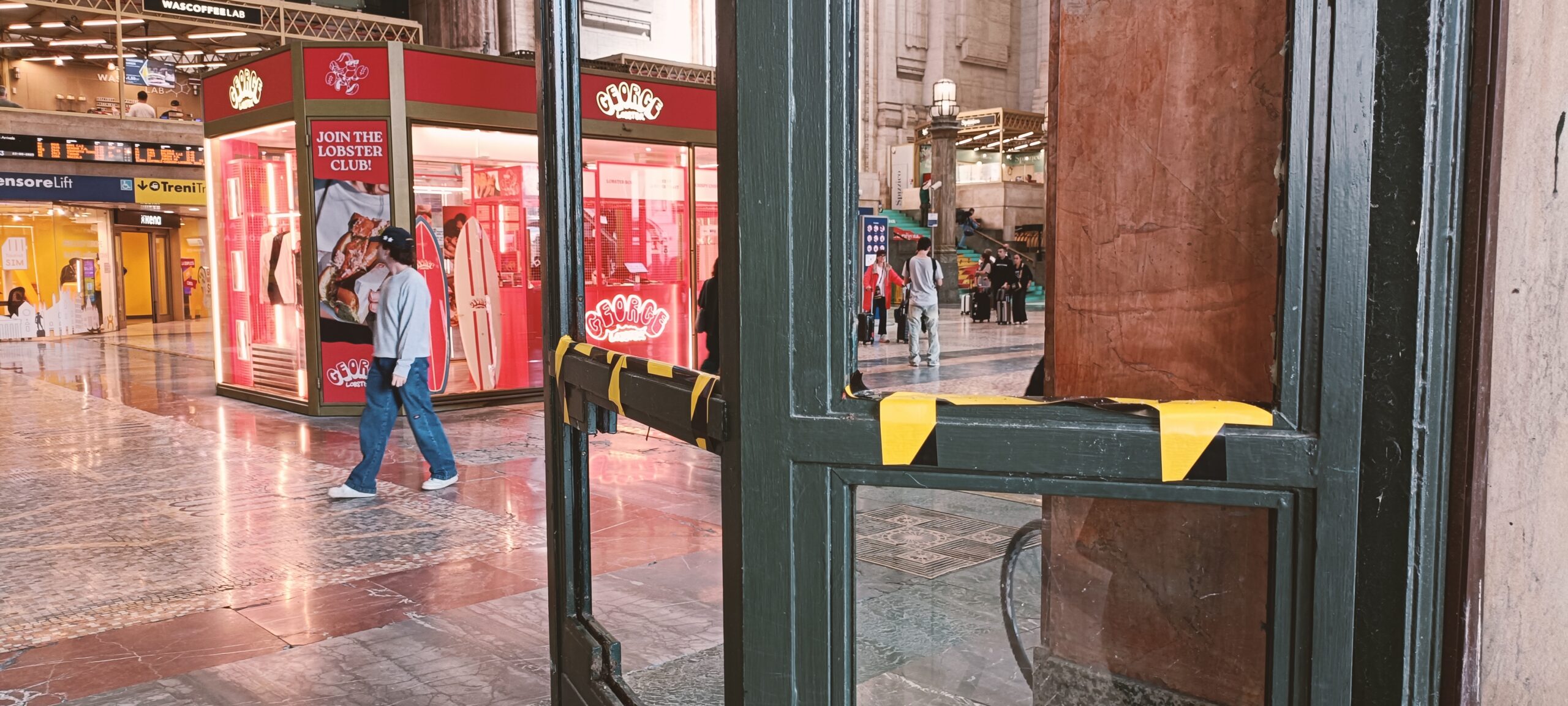 “Milano distrutta dalla guerriglia” come raccontano giornali e tv? Il giorno dopo alla stazione Centrale è tutto normale, mancano solo i vetri a due portoni