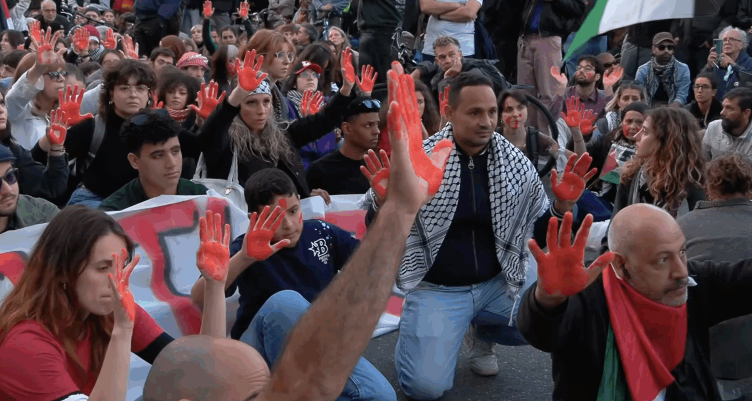 Flotilla, flash mob a Milano: manifestanti con mani e volti dipinti di rosso in piazzale Loreto