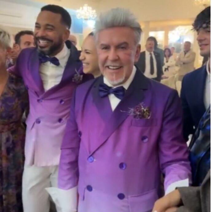 “Come David Beckham”: Alviero Martini sposo a 75 anni con William de Souza, gli abiti (e la torta) viola sono già virali