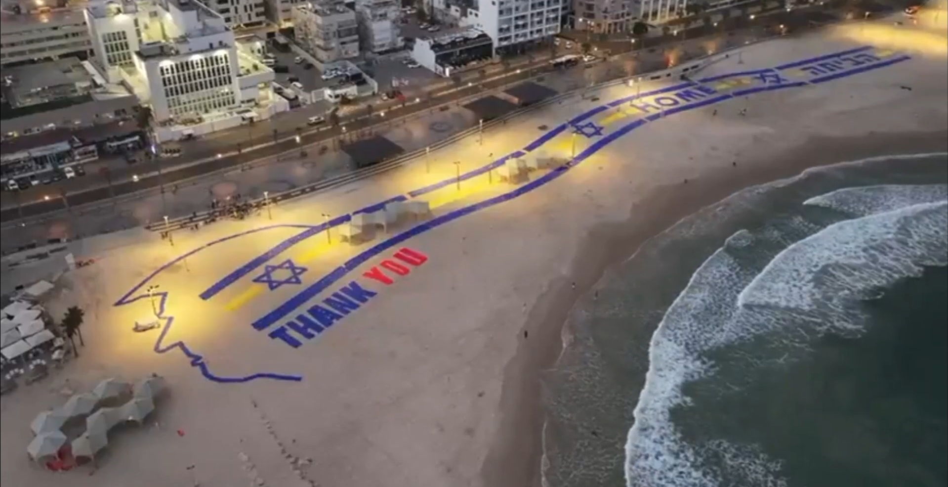 la scritta grazie e il profilo del volto di trump disegnati sulla spiaggia di tel aviv il tributo di israele per il presidente usa