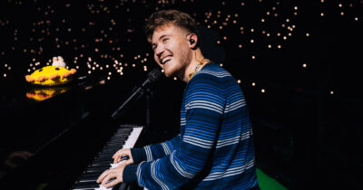 Copertina di “Non ho presentato nessuna canzone per Sanremo 2026. Non esiste l’arte senza pause. Studierò per la patente, starò con i miei e viaggerò”: la smentita di Alfa