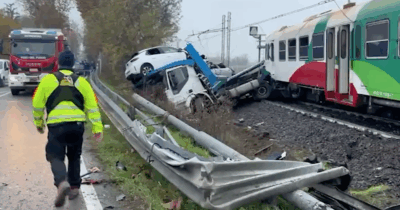Copertina di Camion bisarca contro un treno regionale nel Ferrarese: auto distrutte e circolazione interrotta