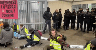 Copertina di Blitz di Extinction Rebellion alla fiera dell’Aerospace di Torino: attivisti arrampicati e incatenati davanti all’ingresso