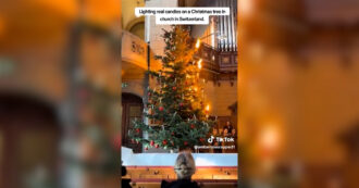 Copertina di L’abete sembra prendere fuoco, poi la magia: la surreale accensione delle candele sull’albero di Natale – Video