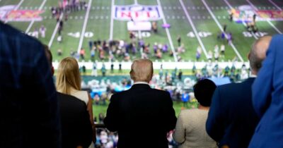 Copertina di Trump assente al Super Bowl per paura dei fischi? Di certo il consenso cala. E sui muri Usa proiettano il “Pedo Bowl”