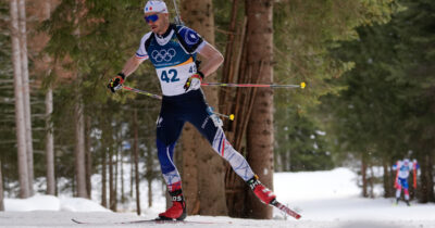Copertina di La medaglia per Pantani, Jacquelin tocca l’orecchino del Pirata e indica il cielo sul traguardo: è bronzo nel biathlon