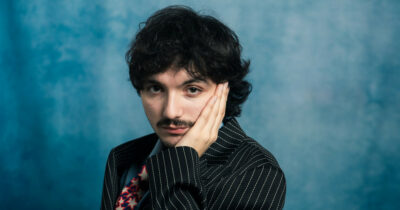 Copertina di “Massimo Troisi mi ha salvato. I numeri degli stream sono una droga, ma il vero successo è vedere le persone ai miei concerti. A Sanremo vado con la PlayStation”: parla Mazzariello