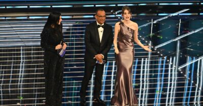 Copertina di Pilar Fogliati a Carlo Conti e Laura Pausini: “Per fare questo lavoro percepite denaro? Ma davvero? Pazzesco”. L’attrice porta il suo personaggio Uvetta sul palco dell’Ariston