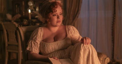 Copertina di “Faccio incazzare la gente perché non ho alcun interesse per la body-positivity. Amo molto l’aspirapolvere e i purificatori d’aria”: Lady Whistledown di Bridgerton spiazza