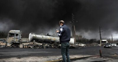 Copertina di Guerra in Iran, a Teheran cade pioggia nera dopo i raid sugli impianti petroliferi: “Restate a casa”