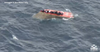 Copertina di Le immagini del barcone ribaltato nel Mediterraneo: i migranti cercano di salvarsi aggrappandosi allo scafo – Video