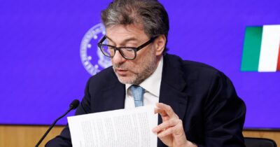 Copertina di La guerra di Trump pesa sui conti italiani: crescita tagliata a +0,6% (e il dato è già vecchio). Giorgetti non esclude lo scostamento di bilancio