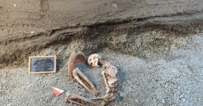 Copertina di Un mortaio sulla testa e dieci monete in tasca: l’Intelligenza Artificiale ricostruisce la disperata fuga di due uomini da Pompei durante l’eruzione