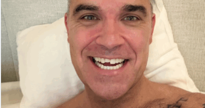 Copertina di “Sembro scemo e più scemo. Mi sono lavato i denti, poi la mia lingua stava esplorando qualcosa di nuovo… una nuova fessura, un nuovo angolino”: Robbie Williams perde mezzo dente