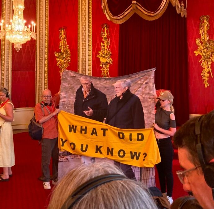 “Cosa sapevano Carlo e William? La monarchia sopravvive grazie alla segretezza”: un lenzuolo con la foto di Andrea ed Epstein nella sala del trono a Buckingham Palace