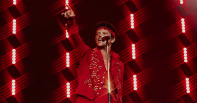 Copertina di “Grazie Dio, proteggi il pubblico e donaci la forza”: Bruno Mars fa ballare San Siro in una discoteca Anni 70 e omaggia l’Italia su una vespa con la sciarpa della Nazionale. Prima si è abbuffato di carbonara