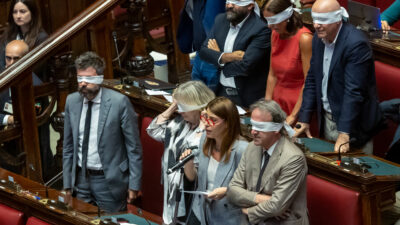 Copertina di Delmastro, il voto alla Camera: la destra vuole bloccare l'uso delle chat. Conte: "Smettetela di invocare Borsellino". Deputati Avs si bendano