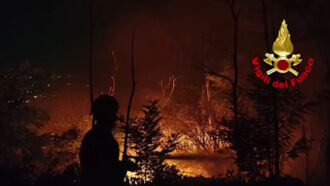 Copertina di Brucia il monte Goj nel Comasco, le fiamme lambiscono le case: 50 persone evacuate