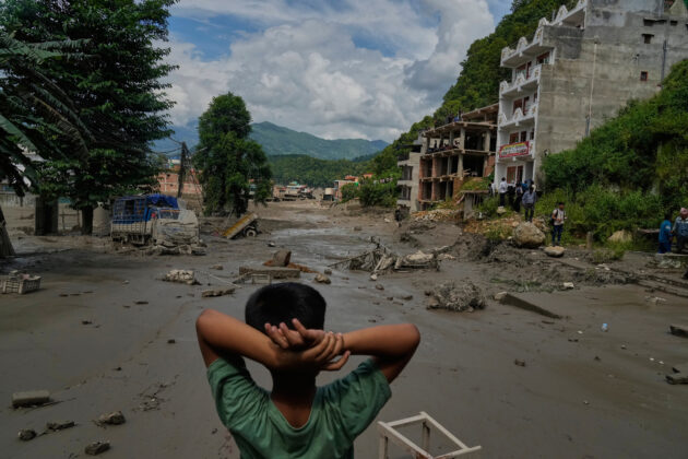 Il bambino che guarda la devastazione e le vittime trasportate sulle ruspe: le foto simbolo dell’alluvione in Nepal