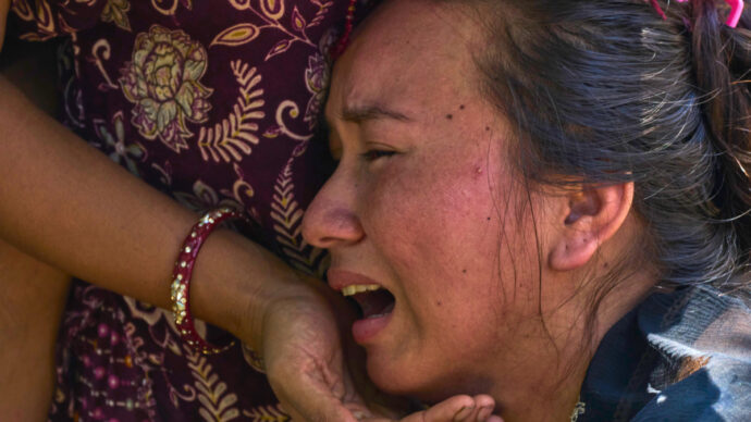 Il bambino che guarda la devastazione e le vittime trasportate sulle ruspe: le foto simbolo dell’alluvione in Nepal