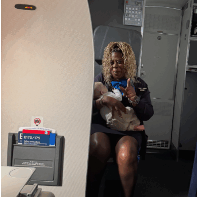La mamma si addormenta in volo con il neonato in grembo, il piccolo sta per scivolare: l’assistente di volo interviene e la foto del gesto conquista i social