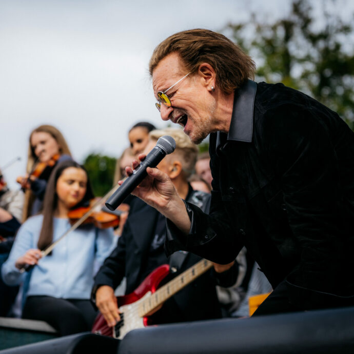 “Se il mondo è avvolto dall’oscurità, noi non dobbiamo esserlo”: gli U2 tornano a scuola 50 anni dopo il primo concerto nel cortile del Mount Temple di Dublino – VIDEO