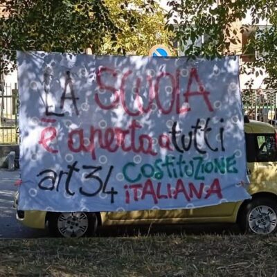 Copertina di “La scuola è aperta a tutti”: lo striscione affisso a Pinerolo e rimosso dai Carabinieri è tornato dov’era