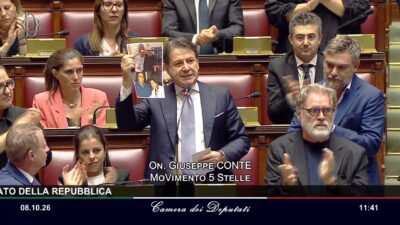 Copertina di Legge elettorale, Conte mostra in Aula le foto di Colosimo (FdI) con Ciavardini e di Delmastro con Caroccia – Video